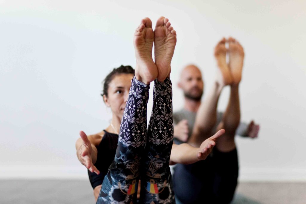 yoga i Uppsala Kvinna och man utför yoga positionen Navasana (Båten) Uppsala