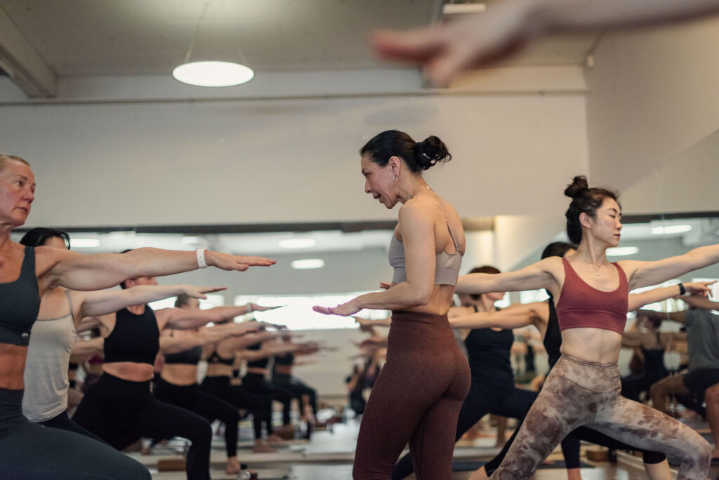 Yoga för nybörjare i Uppsala: en full klass i krigaren med läraren mitt i salen